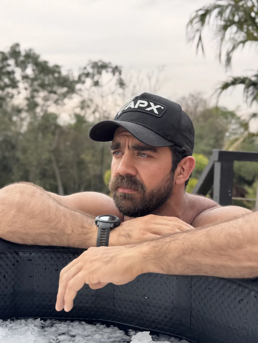 Gabriel, fundador da Apex, apoiado na borda de uma banheira de gelo, de boné da Apex
